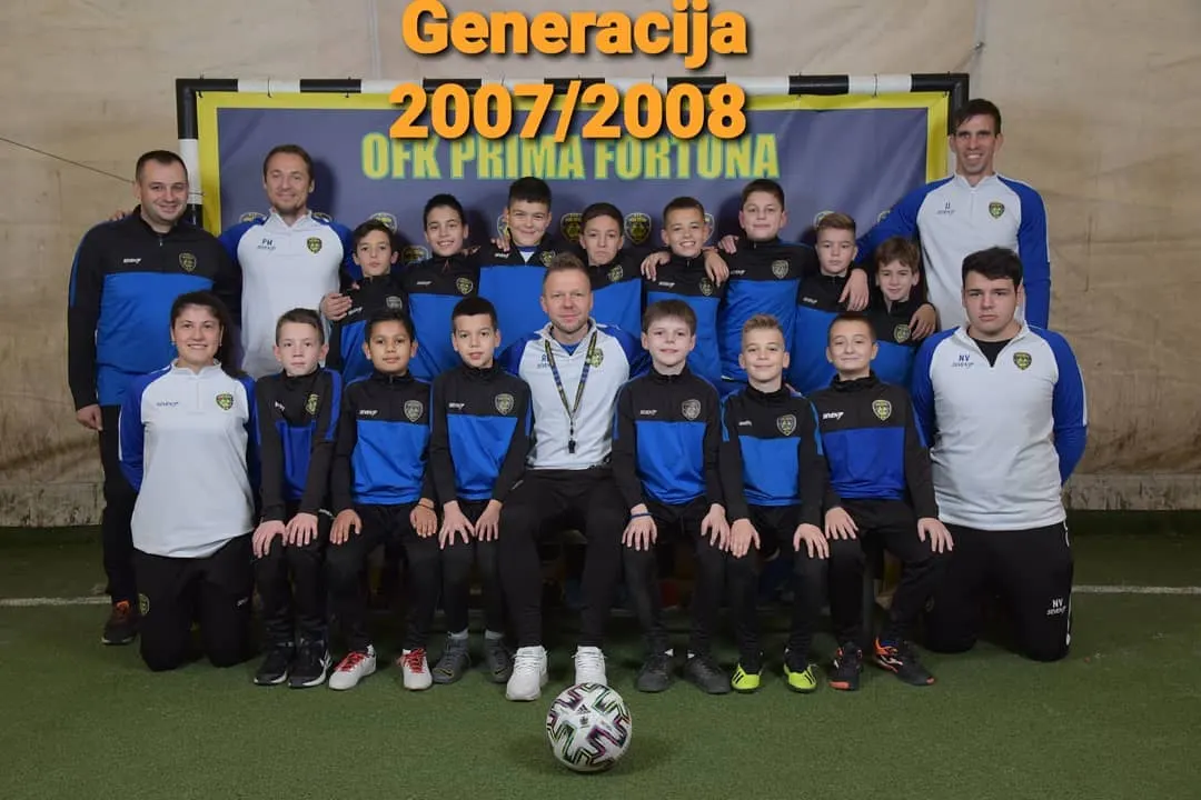 Generacija 2007/2008 sa trenerima ispred klupskog panoa