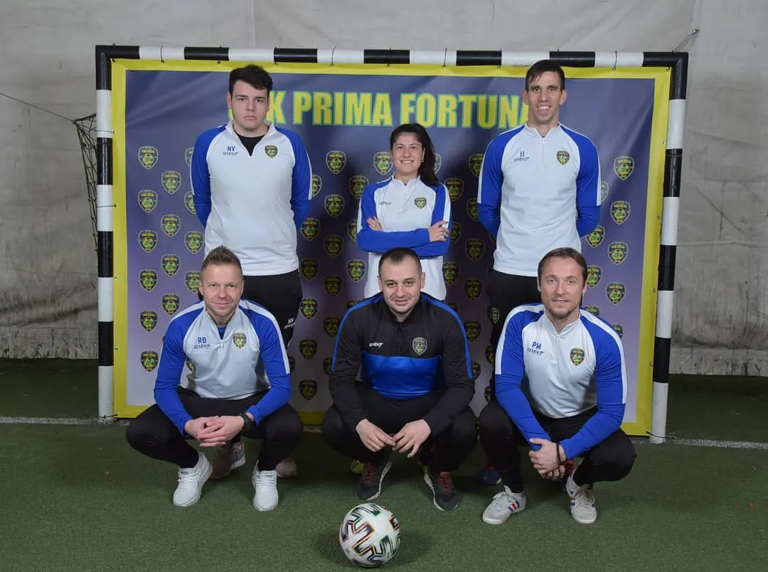 Šestoro ljudi u klupskim trenerkama ispred klupskog panoa